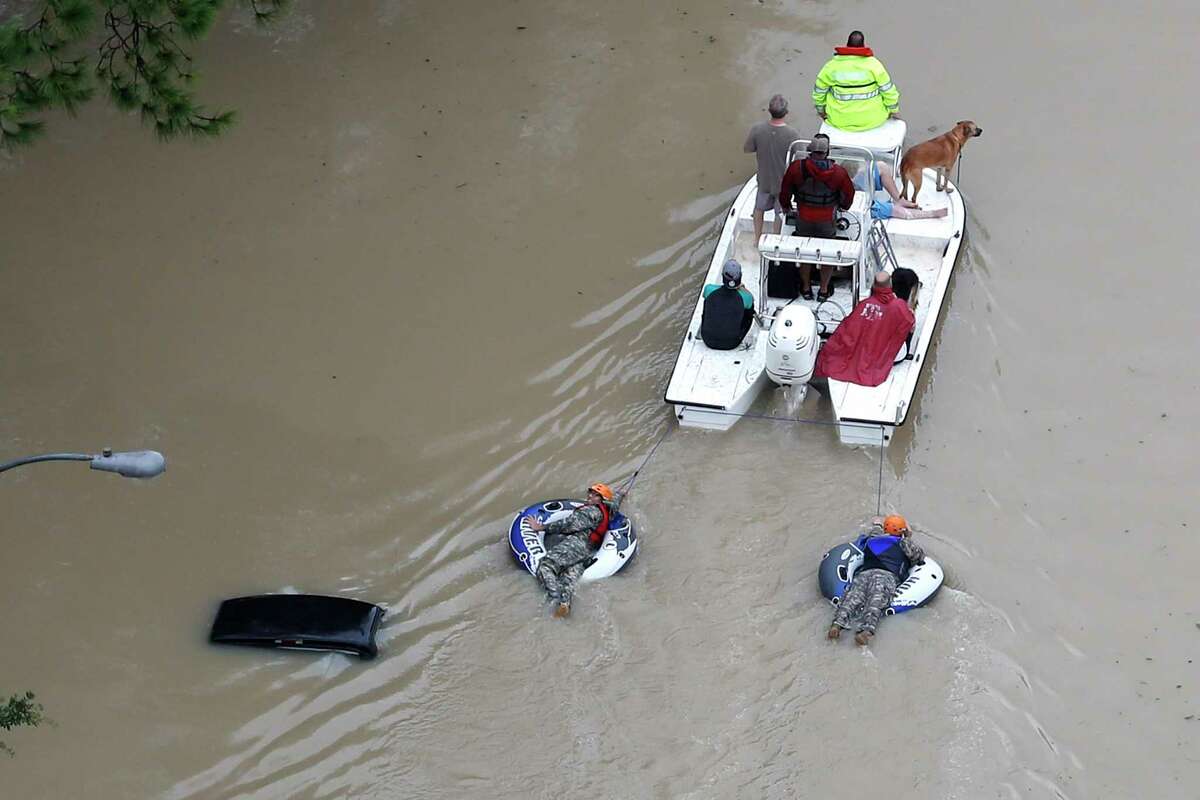 Flood victims are evacuated by boat from their neighborhood near the Addicks Reservoir as floodwaters rise from Tropical Storm Harvey on Tuesday, Aug. 29, 2017, in Houston.