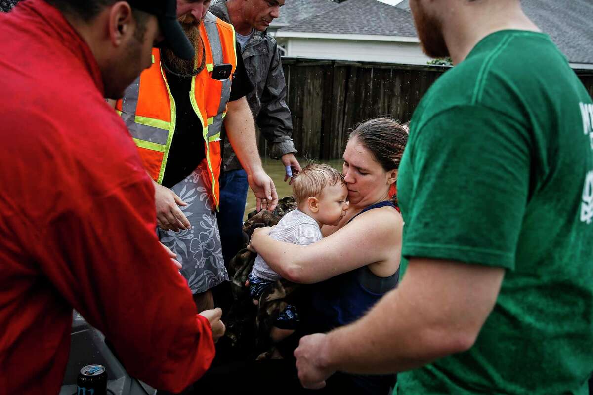 Lauren Durst holds onto her ten-month-old son, Wyatt Durst, as they evacuate from the Savannah Estates neighborhood as Addicks Reservoir nears capacity Tuesday, Aug. 29, 2017 in Houston.