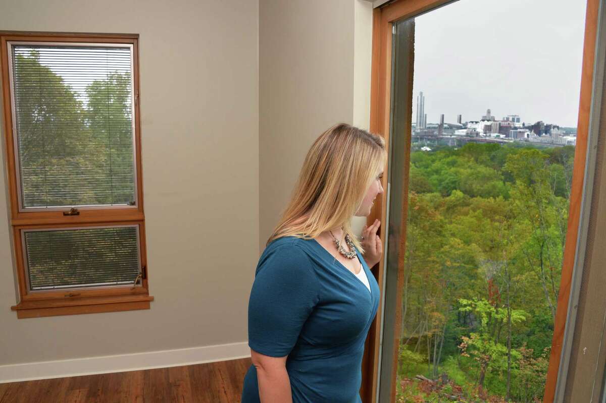 Renssealer County Chamber of Commerce's Staci O'Neill checks out the view of the Albany skyline during a tour of the new luxury Falls Edge Apartments on High Street Tuesday August 29, 2917 in Rennselaer, NY. (John Carl D'Annibale / Times Union)