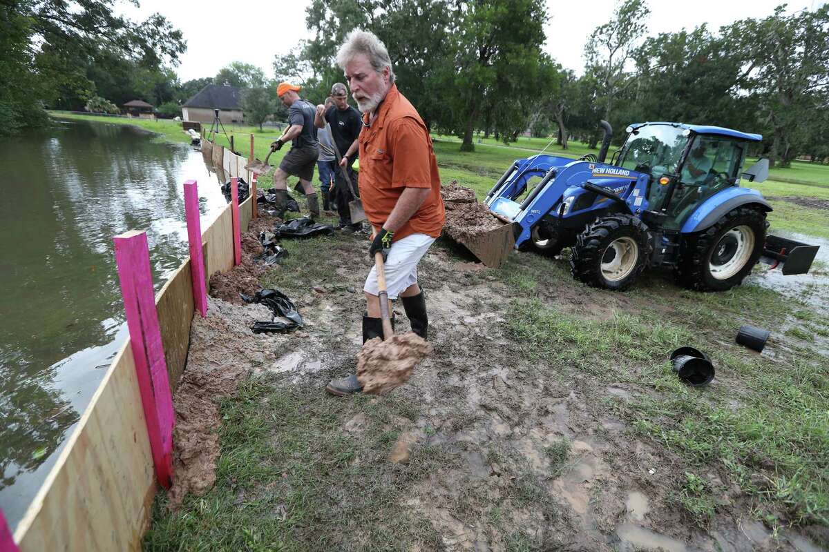 Keith Bailey helps shore up the levee of the Varner Creek in the Columbia Lakes subdivision in West Columbia on Tuesday.