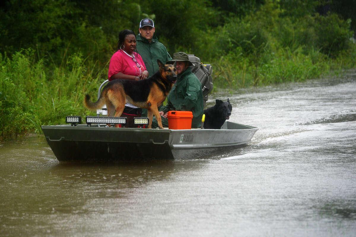 Sarah Sells rides on a boat with her two German shepherds that flooded their home on Tram Road in Beaumont on Tuesday. Volunteers convened in the area with their boats to help rescue residents and their animals. Photo taken Tuesday 8/29/17 Ryan Pelham/The Enterprise
