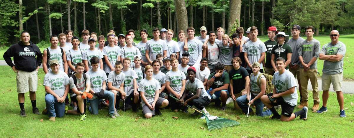 About 60 members of the New Milford High School football team, led by Coach Larry Badaracco, left, and Assistant Coach Chuck Lynch, participated in a community cleanup project at Harrybrooke Park & Harden House Museum Aug. 25.
