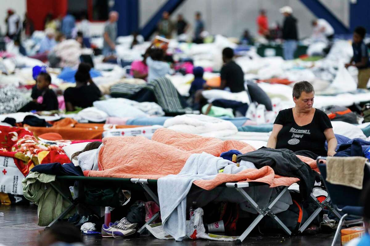 Mary Colson sits on a cot at the George R. Brown Convention Center where nearly 10,000 people are taking shelter after Tropical Storm Harvey Wednesday, Aug. 30, 2017 in Houston.