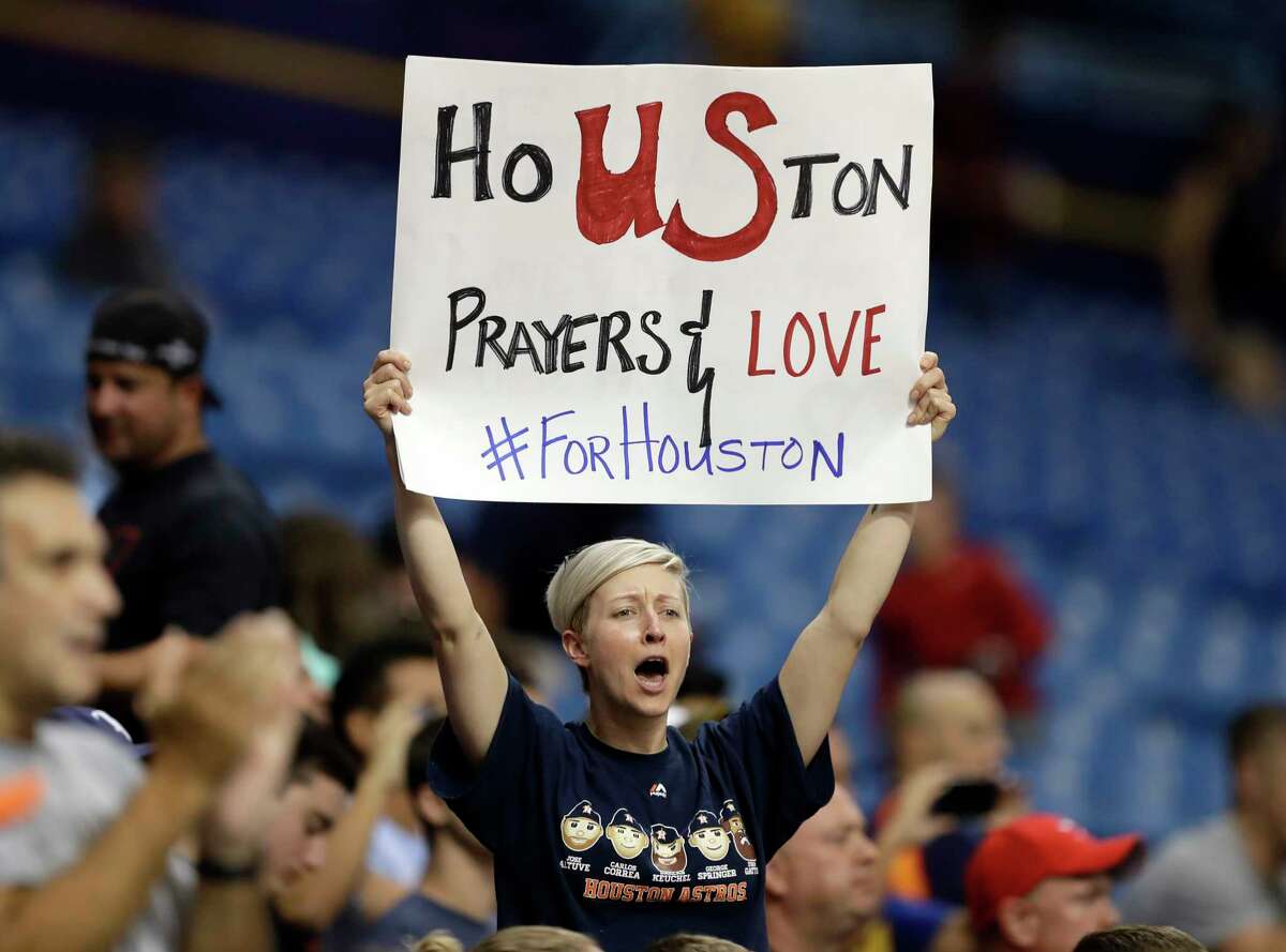 Katie Churchwell holds up a sign during the first inning of a baseball game between the Houston Astros and the Texas Rangers on Tuesday, Aug. 29, 2017, in St. Petersburg, Fla. The Astros moved their three-game home series against the Rangers to St. Petersburg because of unsafe conditions from Hurricane Harvey. (AP Photo/Chris O'Meara)