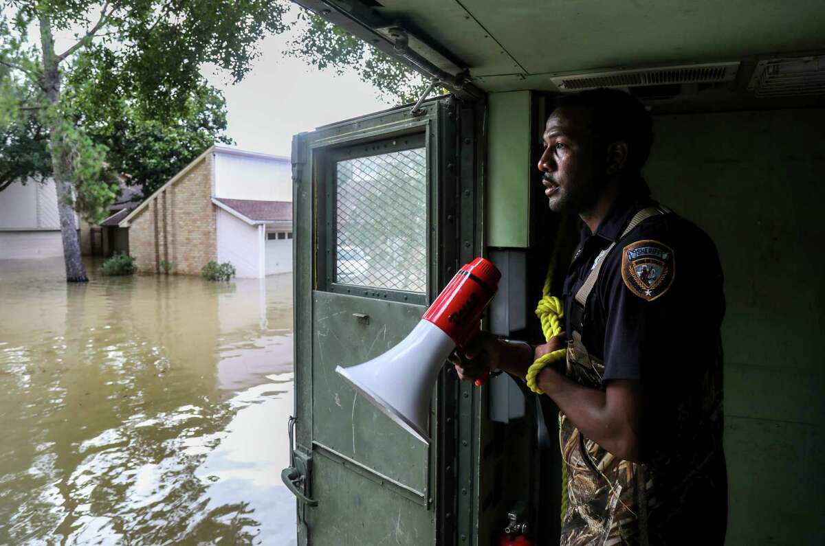Harris County Sheriff's Deputy Rick Johnson pauses to listen for people's voices as they search for people in a neighborhood inundated by water from the Addicks Reservoir, Wednesday, Aug. 30, 2017, in Houston.