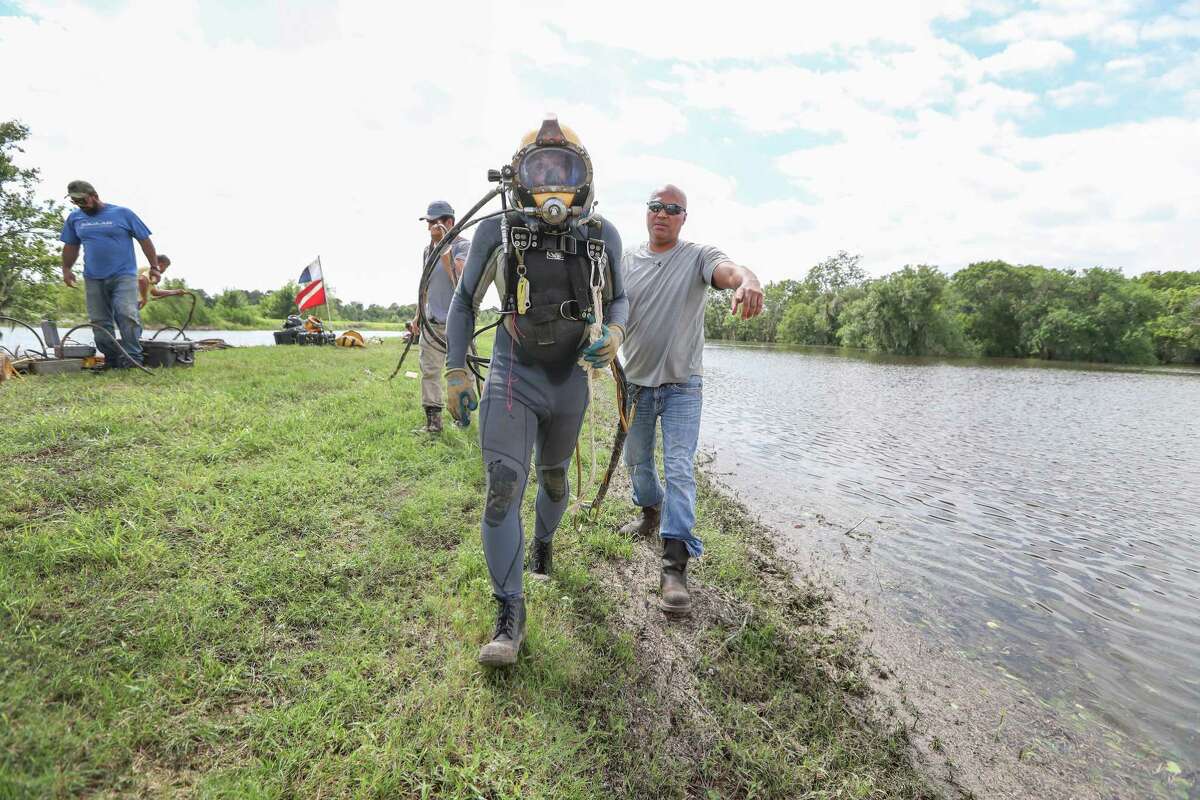 Saltwater Salvage diver Justin Hendrickson prepares to dive near the Columbia Lakes subdivision Wednesday, Aug. 30, 2017, in West Columbia. Hendrickson was walked to the dive spot by fellow diver Dave Oltroge before he dove to shut a levee gate value to prevent more flooding to the neighborhood.
