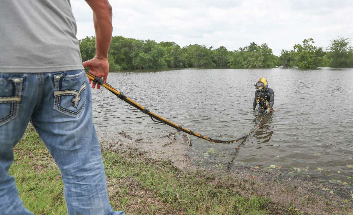 Saltwater Salvage diver Justin Hendrickson prepares to dive near the Columbia Lakes subdivision Wednesday, Aug. 30, 2017, in West Columbia. Hendrickson was assisted by fellow diver Dave Oltroge before he dove to shut a levee gate value to prevent more flooding to the neighborhood.