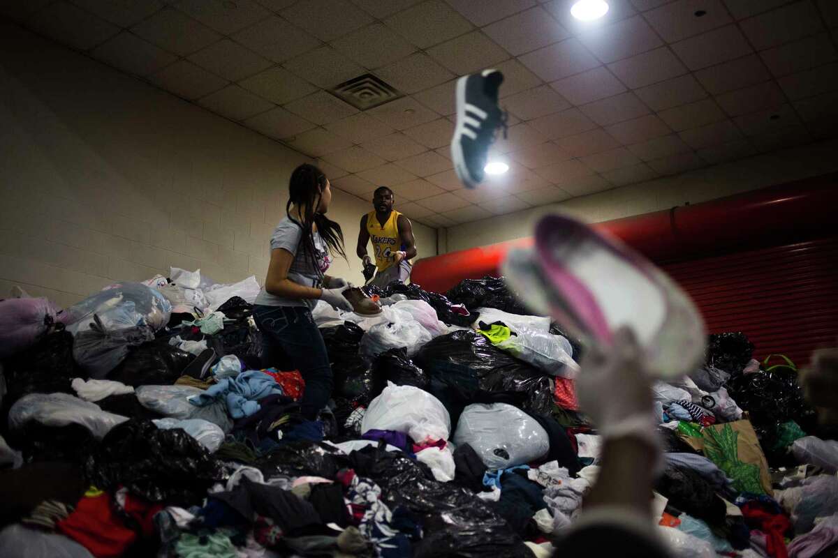 A woman picks through clothing at the George R. Brown Convention Center in Houston.
