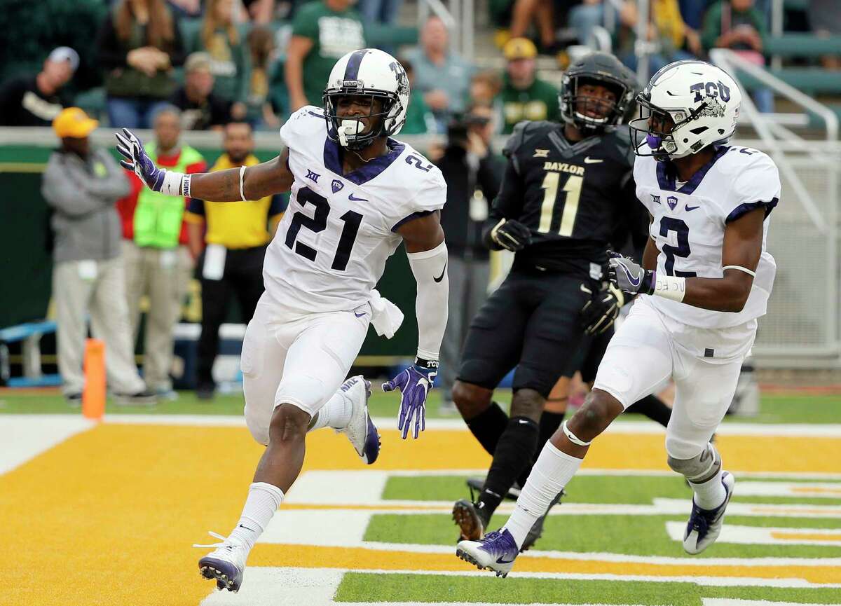 FILE - In this Nov. 5, 2016, file photo, TCU running back Kyle Hicks (21) celebrates his touchdown run with wide receiver Taj Williams (2) as Baylor cornerback Jameson Houston (11) watches during an NCAA college football game in Waco, Texas. Hicks can run and catch for TCU. He leads the team with 894 yards rushing and 40 receptions, putting him on pace to be the first player to lead both categories since Basil Mitchell in 1996. (AP Photo/Tony Gutierrez, File)