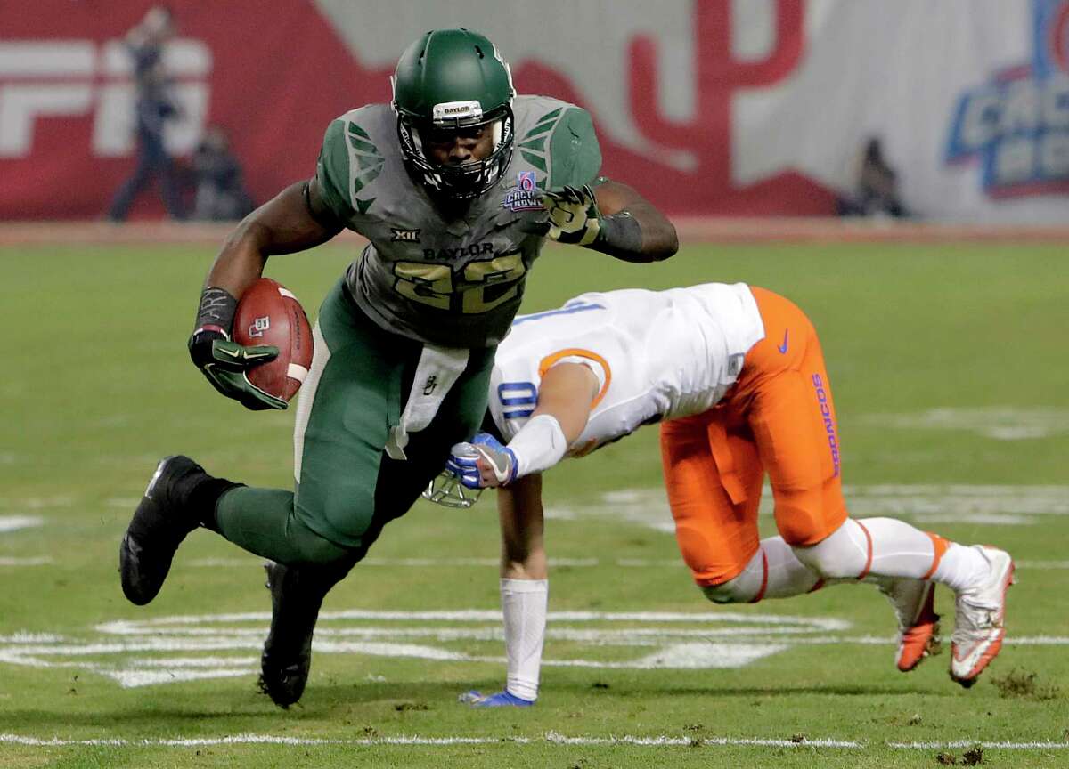 Baylor running back Terence Williams (22) escapes the grasp of Boise State safety Kekoa Nawahine (10) during the first half of the Cactus Bowl NCAA college football game, Tuesday, Dec. 27, 2016, in Phoenix. (AP Photo/Rick Scuteri)