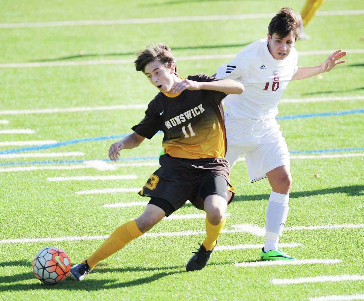 At left, Alberto Delgado (#11) of Brunswick is pulled down from behind by Salisbury's Miguel Garcia Palencia Oliver (#16), right, for a penalty during the boys high school soccer match between Brunswick School and Salisbury School at Brunswick in Greenwich, Conn., Wednesday, Oct. 19, 2016. Dante Polvara of Brunswick was selected to shoot the penalty kick that he scored for the first goal of the game.