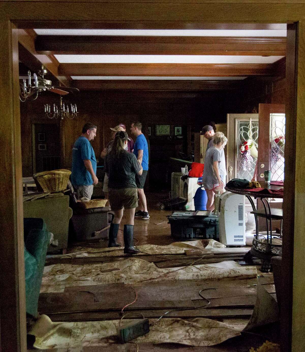 Friends and neighbors help clear the home of Chris Roberts, left, after floodwater damage from Tropical Storm Harvey in McDale Estates, Wednesday, Aug. 30, 2017, in Conroe.