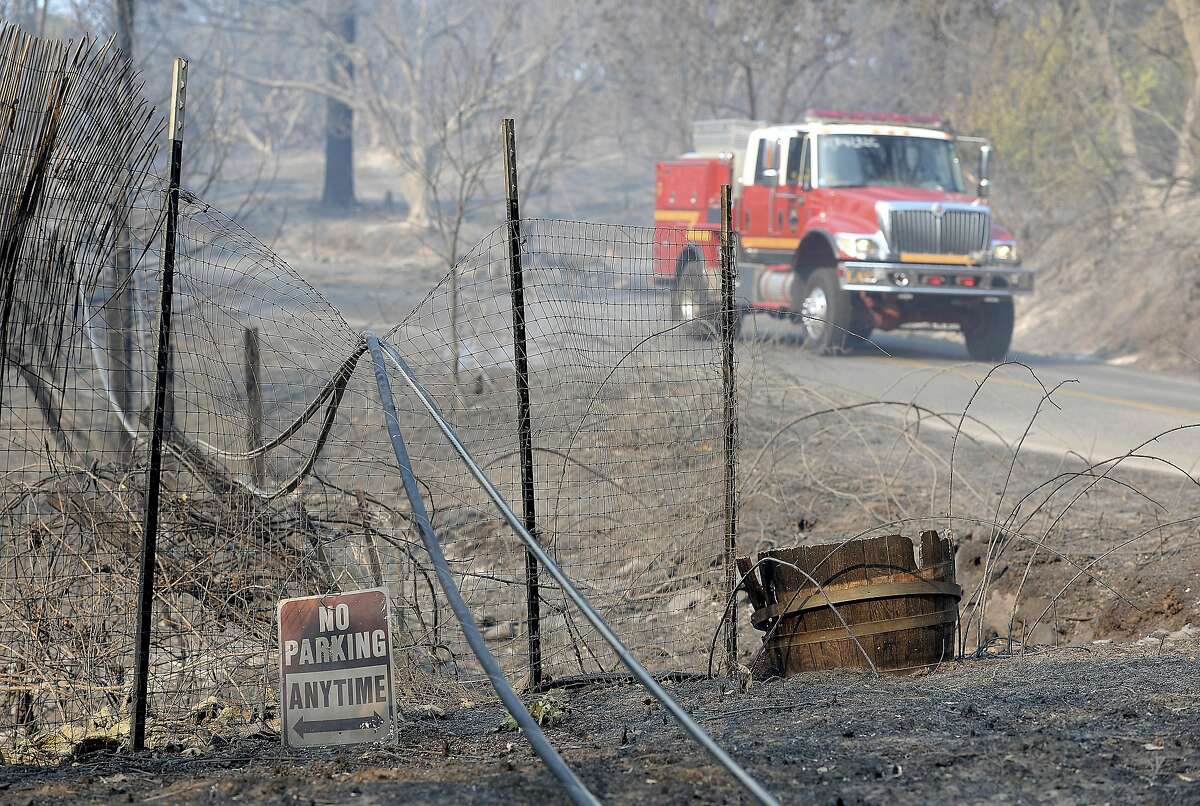 A fire truck working on a wildfire drives past downed power lines along Lumpkin Road near Oroville, Calif., Wednesday, Aug. 30, 2017. The wildfire is among a series of wildfires burning across the U.S. West. (Bill Husa/Chico Enterprise-Record via AP)