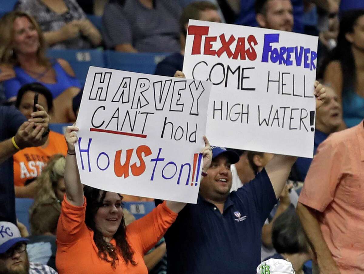 Fans hold up signs as a show of support for the city of Houston during the sixth inning of a baseball game between the Houston Astros and the Texas Rangers Wednesday, Aug. 30, 2017, in St. Petersburg, Fla. The Astros moved their three-game home series against the Rangers to St. Petersburg after being displaced by Hurricane Harvey. (AP Photo/Chris O'Meara)