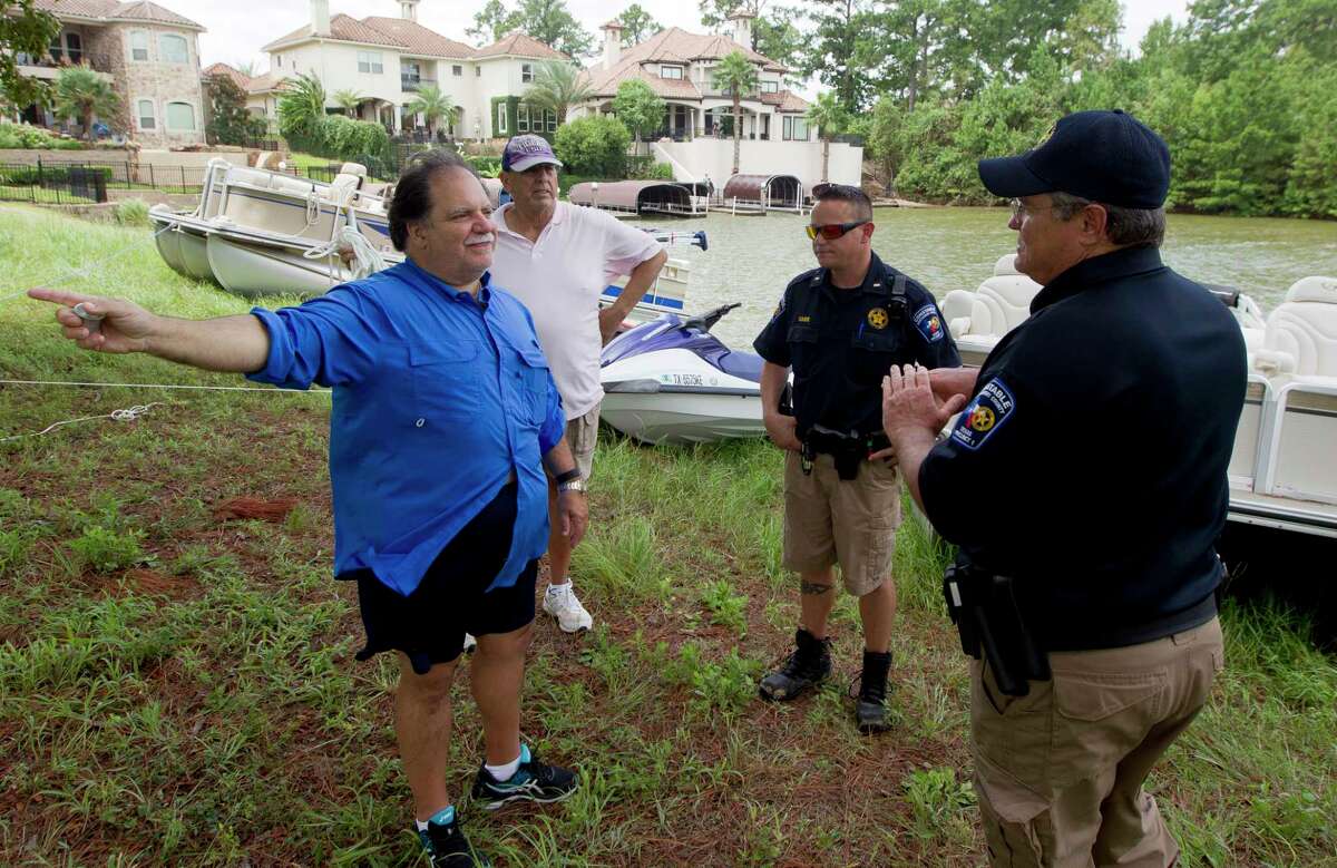 Dan Orsini points out areas to deputies from Montgomery County Constable's Office where unsecured boats might have drifted. to on Lake Conroe, Wednesday, Aug. 30, 2017, in Conroe.