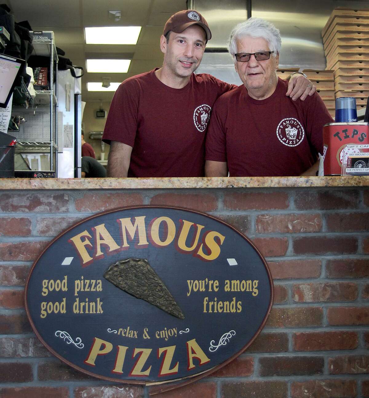 Perry and George Anastasakis sit at a table on Wednesday, Aug. 30, 2017, in their restaurant Famous Pizza, which has been opein for 35 yeras in Bethel, Conn.