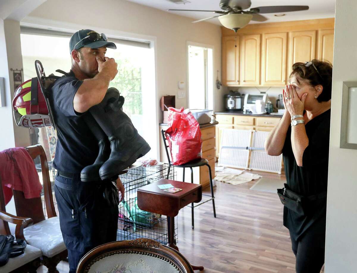 Sharlene Barris, right, tears up when she sees Houston Fire Capt. Joshua Vogel as he did home welfare checks in the Meyerland area Thursday. Vogel's team evacuated Barris and her husband as waters rose into their home.