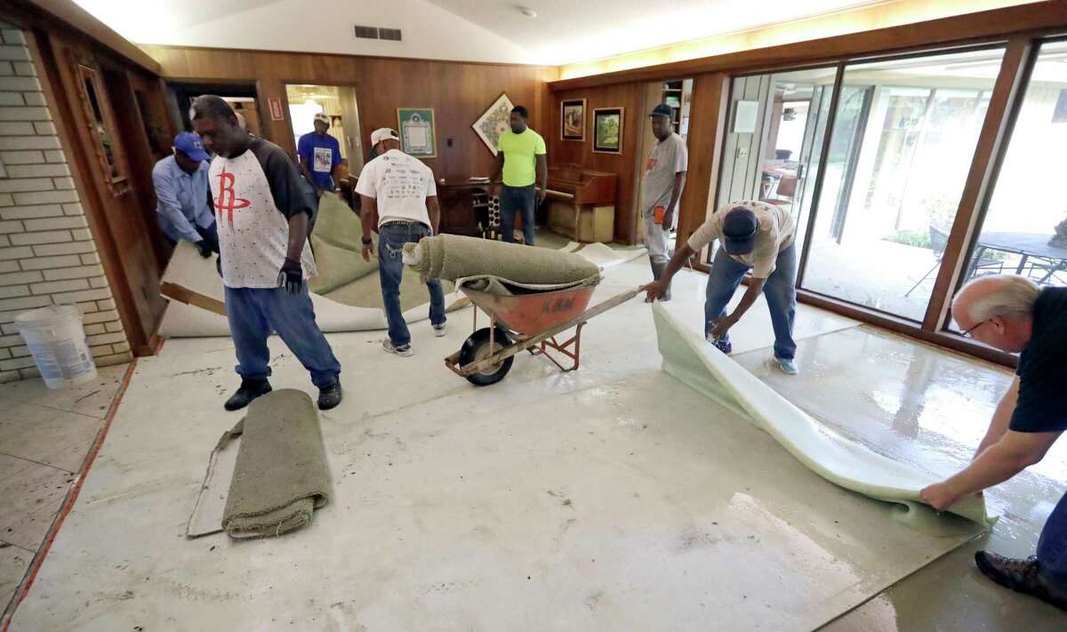 Workers remove carpet damaged by floodwaters from Tropical Storm Harvey from a home Wednesday, Aug. 30, 2017, in Houston. (AP Photo/David J. Phillip)