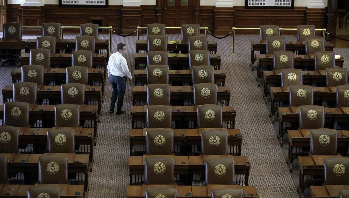 The special session ended in mid-August, but the rhetoric about what it accomplished did not. Both Gov. Greg Abbott and Lt. Gov. Dan Patrick cast blame for bills left undone. Here, Chris Currens, who works in the office of the sergeant-at-arms in the Texas House, walks through an empty chamber on Aug. 16.