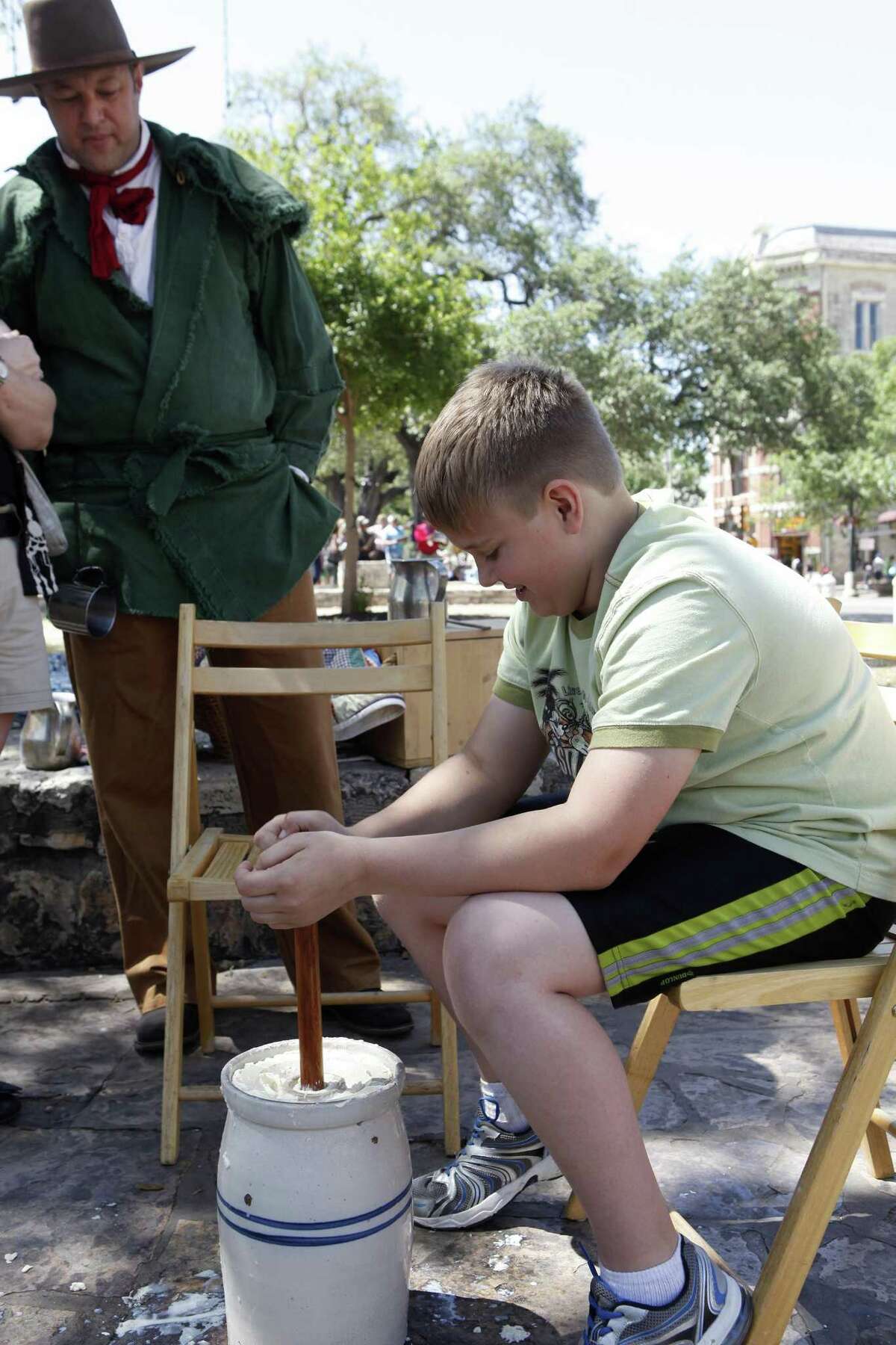 Brayden Israel, 11 churns butter for the first time May 3, 2014, during the San Antonio Living History Association's "Visits to the Past" program in front of the Alamo. The program is intended to show how things were in the 1830s around the time of the Battle of the Alamo.