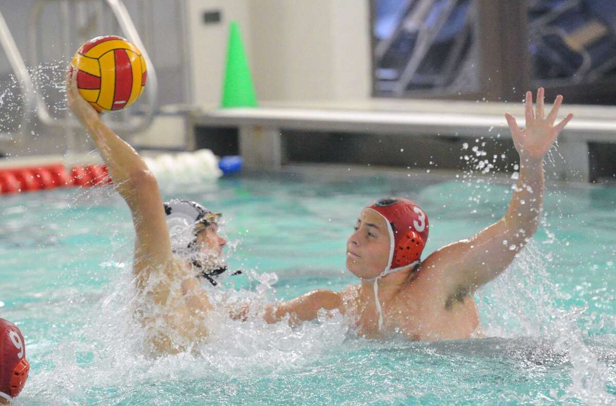 Greenwich’s Tegan D’Agostino (3) , defends on a shot by Brunswick’s Will Marvin during their water polo match last year.