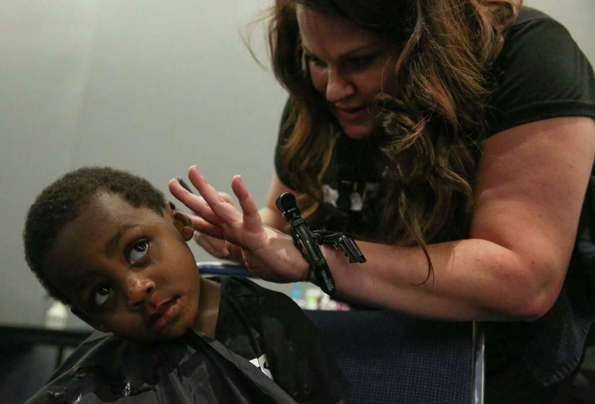 Damarcus Dosie, 2, of Fifth Ward, gets a haircut by hairstylist Melanie Jones at George R Brown Convention Center on Thursday, August 31, 2017, in Houston. About 50 hairstylists volunteered to provide hair services to Hurricane Harvey flood evacuees.