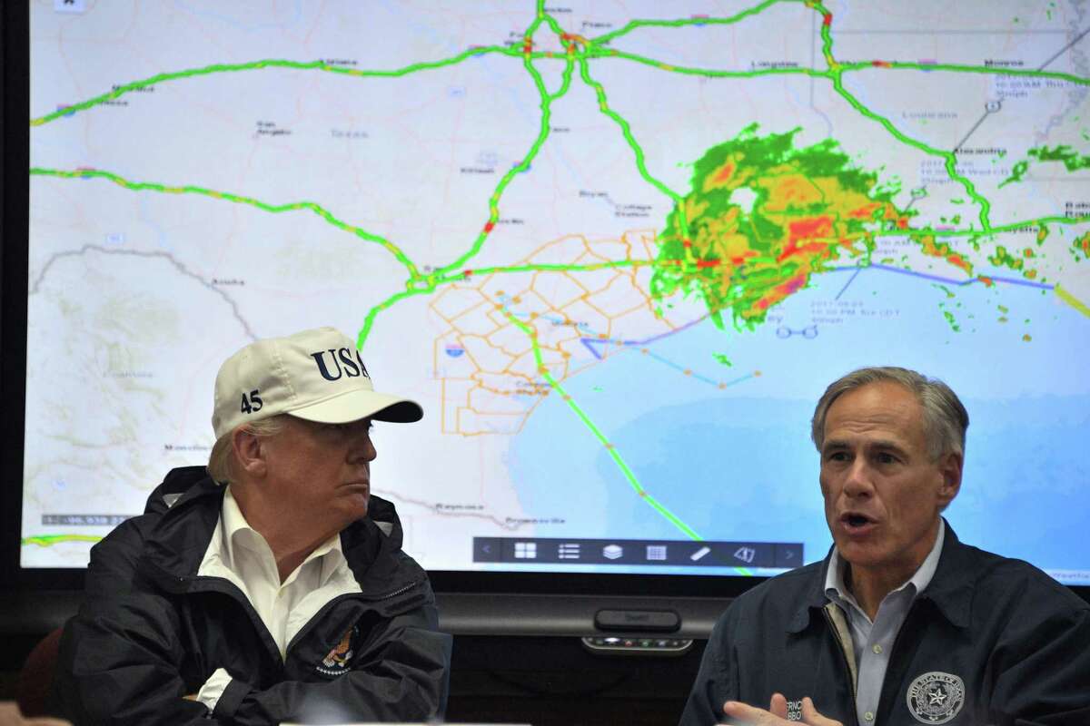 Texas Governor Greg Abbott speaks next to President Donald Trump at the Texas Department of Public Safety Emergency Operations Center in Corpus Christi, Texas on Tuesday. Both have dabbled in climate change denial. Perhaps Harvey will change that.
