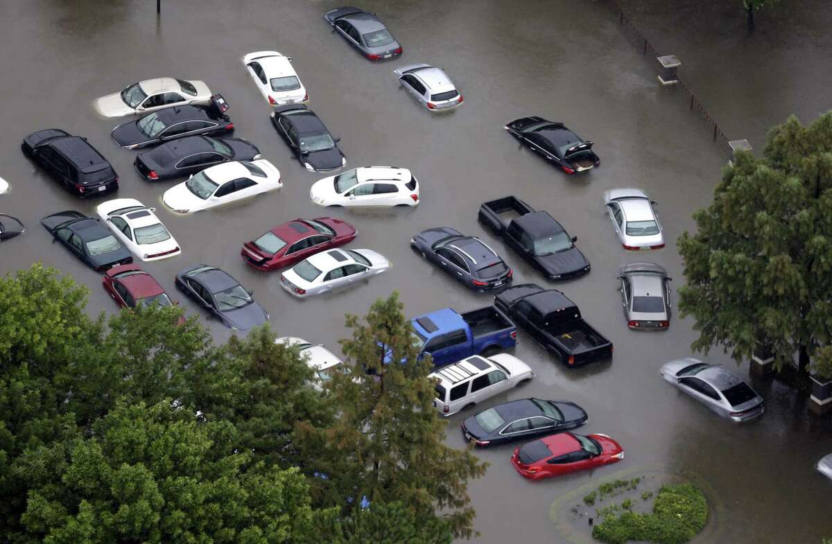 Flooded cars near the Addicks Reservoir are shown as floodwaters from Tropical Storm Harvey rise this week in Houston. Owners likely will shop for new vehicles but up to 500,000 new cars at Houston dealerships also were flooded, according to one estimate.