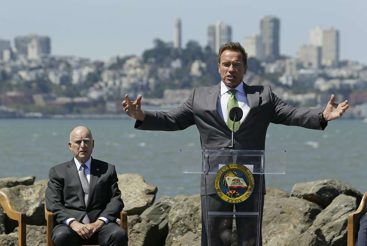 Former California Gov. Arnold Schwarzenegger gestures while speaking as Gov. Jerry Brown, left, listens before a climate bill signing on Treasure Island, Tuesday, July 25, 2017, in San Francisco. Gov. Jerry Brown signed legislation Tuesday keeping alive California's signature initiative to fight global warming, which puts a cap and a price on climate-changing emissions. The Democratic governor was joined by his celebrity predecessor, Arnold Schwarzenegger, who signed the 2006 bill that led to the creation of the nation's only cap and trade system to reduce greenhouse gases in all industries.(AP Photo/Eric Risberg)