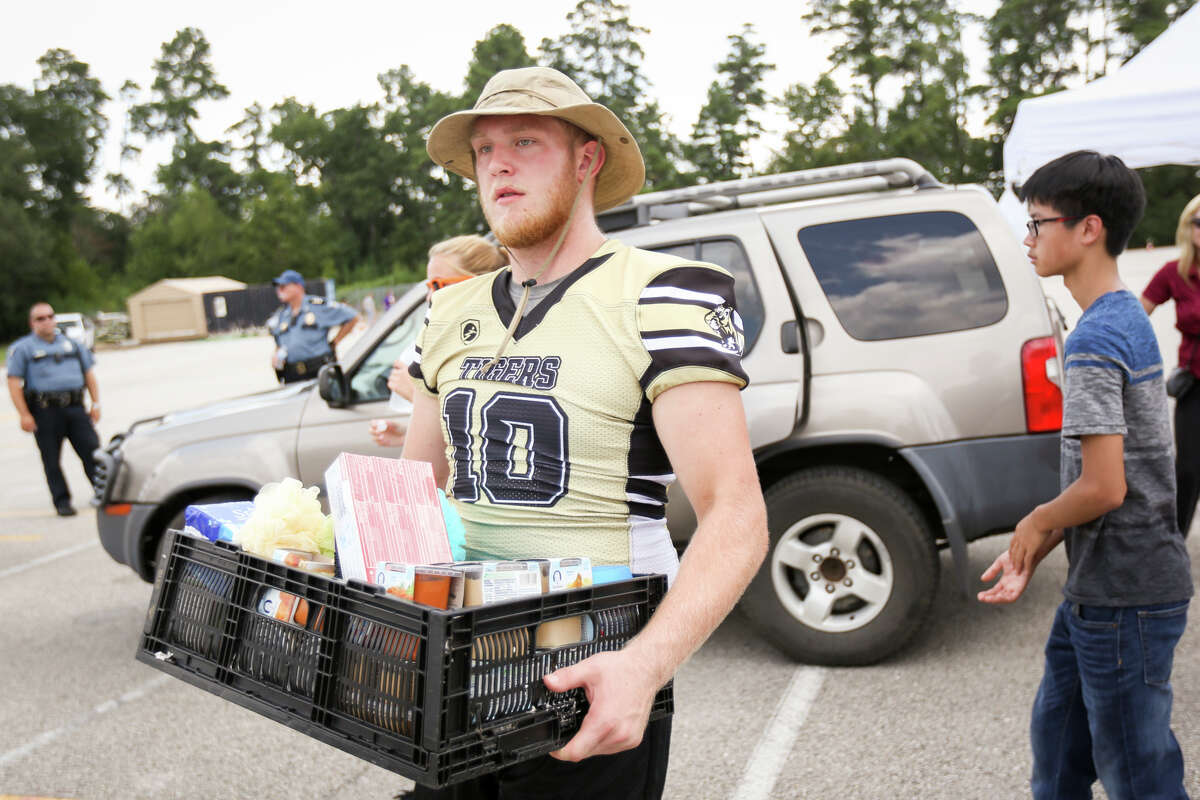 Conroe High School senior Travis Null unloads donations from a car during the Conroe ISD food drive for the Montgomery County Food Bank on Friday, Sept. 1, 2017, at Moorhead Stadium in Conroe.
