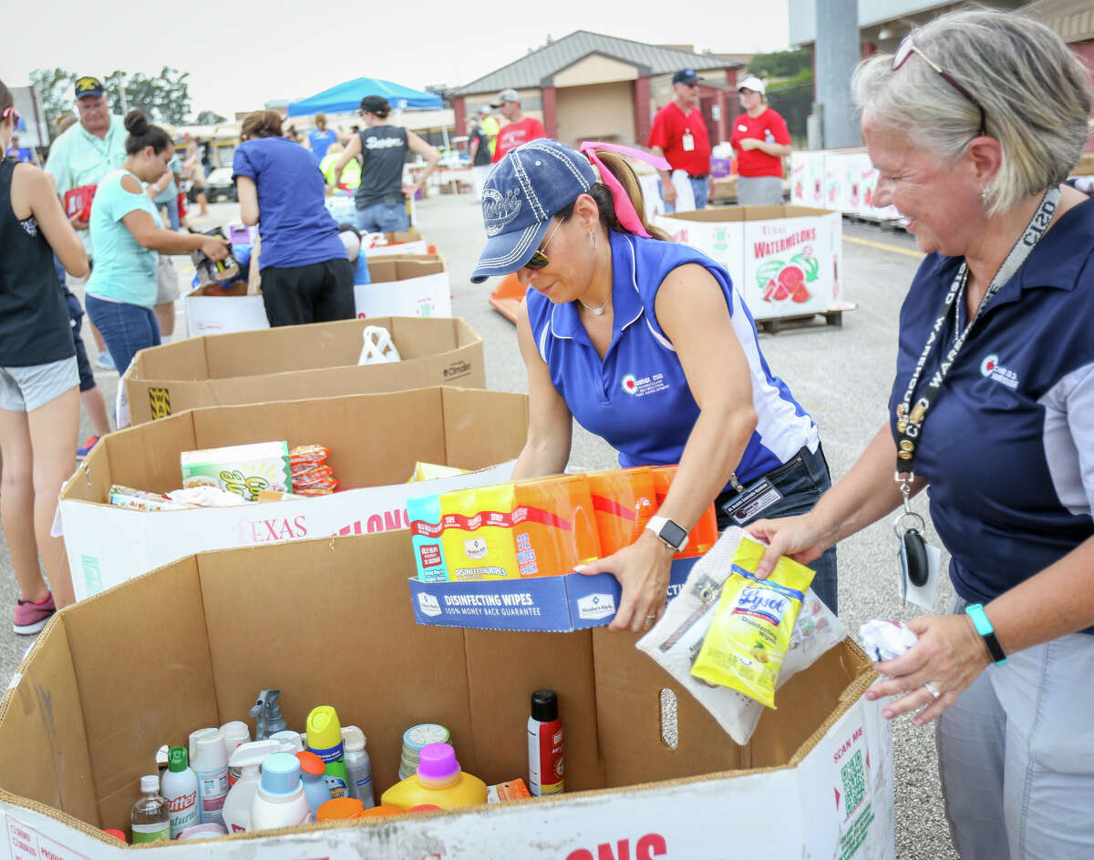 Hedith Upshaw, Conroe ISD Curriculum & Instruction Director, left, and Ellie Bergeron, Conroe ISD Warehouse Supervisor, right, organize donations during the Conroe ISD food drive for the Montgomery County Food Bank on Friday, Sept. 1, 2017, at Moorhead Stadium in Conroe.