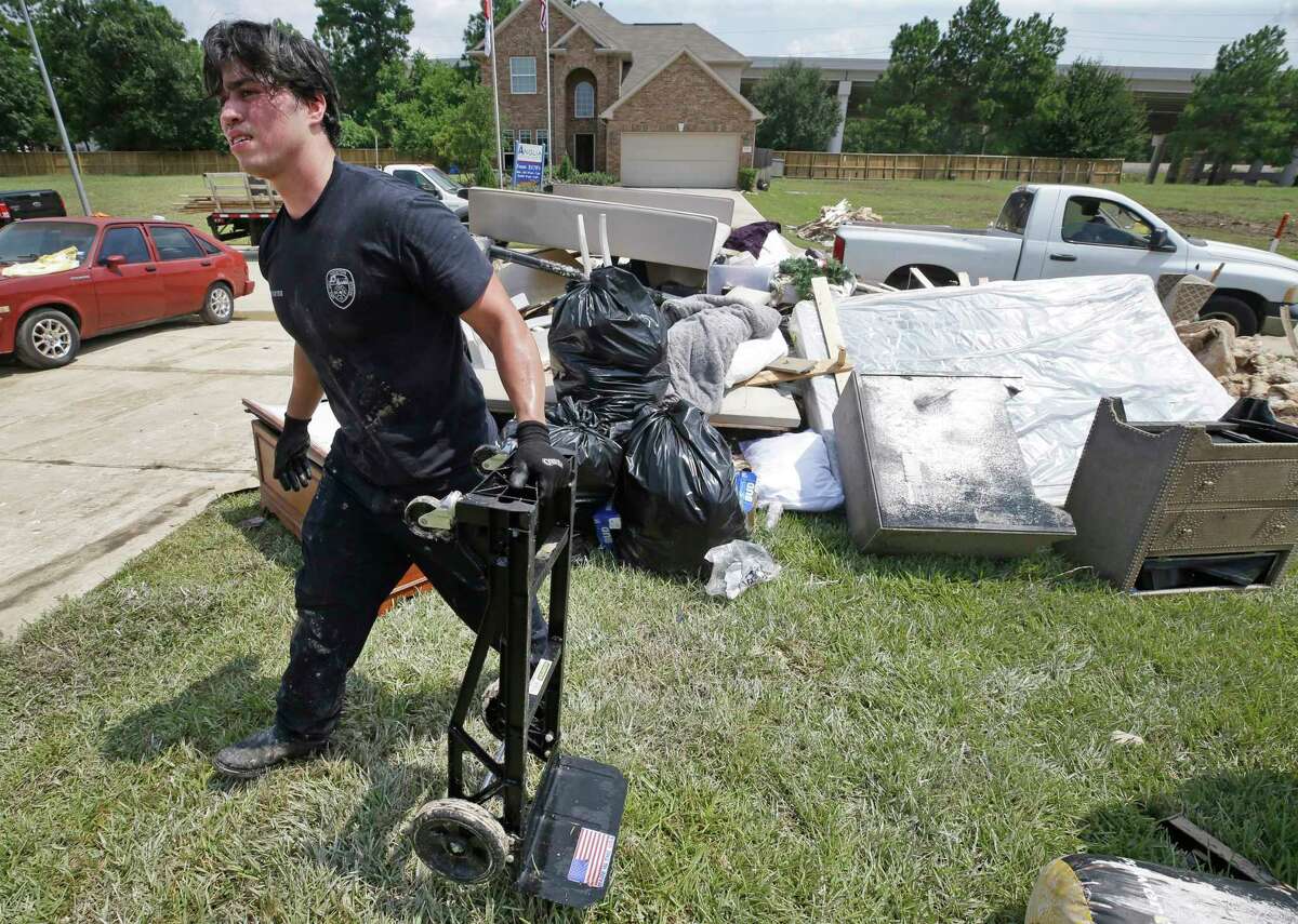 Jordan Morales, a Houston firefighter with Station 9, cleans up his flooded home Friday, Sept. 1, 2017, in Spring. He said about 5 feet of water flooded his home in the aftermath of Hurricane Harvey. He does not have flood insurance. ( Melissa Phillip / Houston Chronicle )
