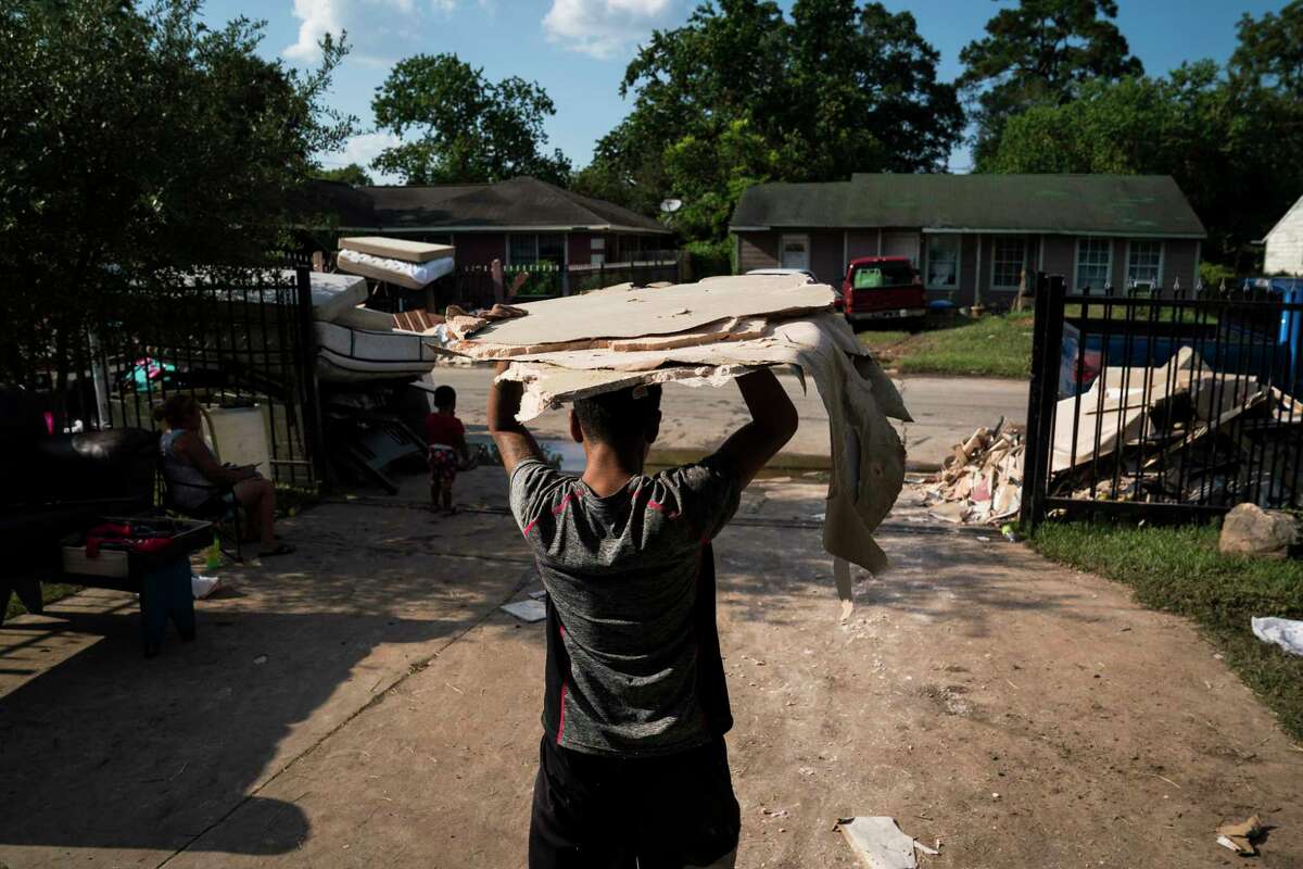 Friends and family members help the Baltazar family begin the rebuilding process at their home on Talton Street in Houston.