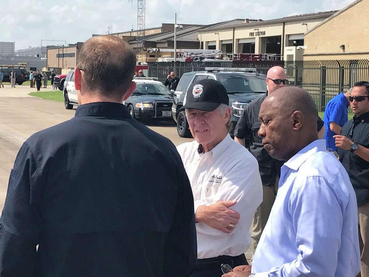 Harris County Judge Emmett (center) & Houston Mayor Turner (right) speaking with Brock Long as they await President Donald Trump's arrival. 