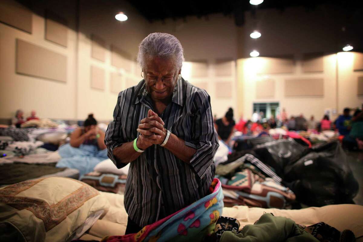 Bernice Emerge, 80, says a tearful prayer at the Woodlands Church in The Woodlands, a suburb north of Houston, where some 200 evacuees were sheltering, Aug. 29, 2017. Tropical Storm Harvey made a second landfall in Louisiana early Wednesday morning, but the emergency was far from over in Texas, where beleaguered residents continued to struggle against rising floodwaters caused by six days of rainfall. (Barbara Davidson/The New York Times)