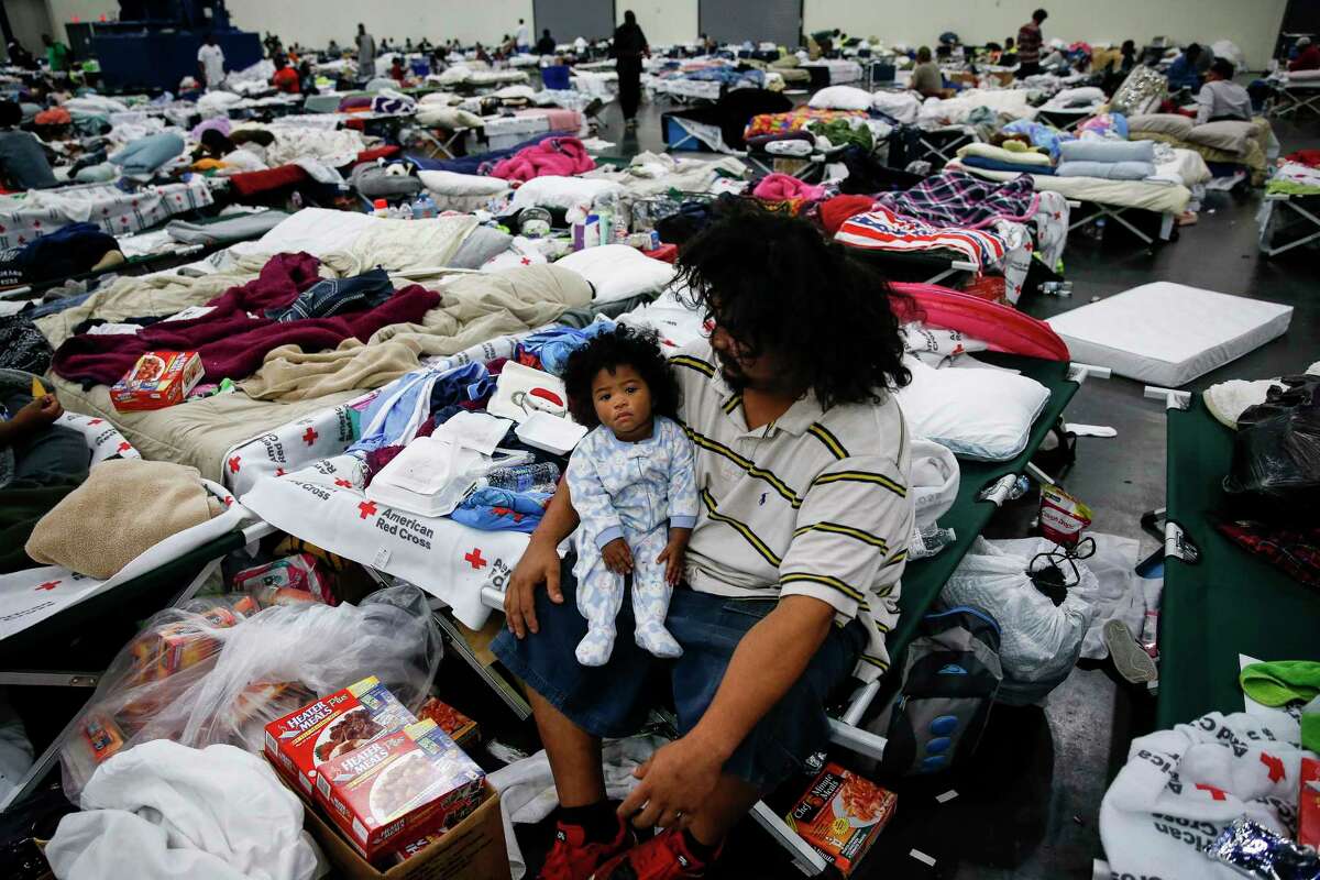 Edgar Molina holds his one-year-old daughter, Miracle Marie Molina, on a cot at the George R. Brown Convention Center where nearly 10,000 people are taking shelter after Tropical Storm Harvey Wednesday, Aug. 30, 2017 in Houston. Molina and his daughter have been at the shelter since Sunday. ( Michael Ciaglo / Houston Chronicle)