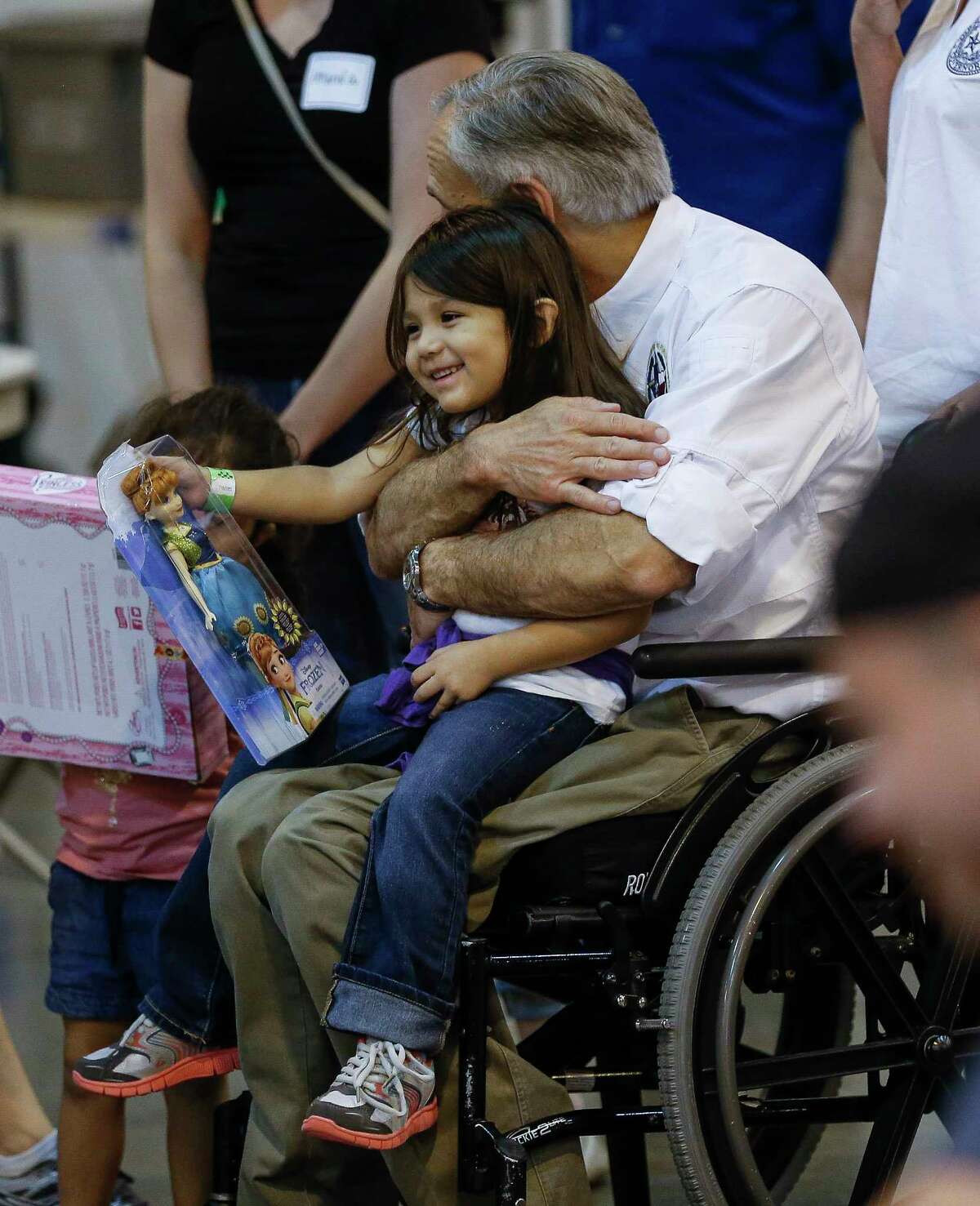 Texas Governor Greg Abbott hugs a child while visiting Tropical Storm Harvey evacuees at NRG Center in Houston Saturday, Sept. 2, 2017.