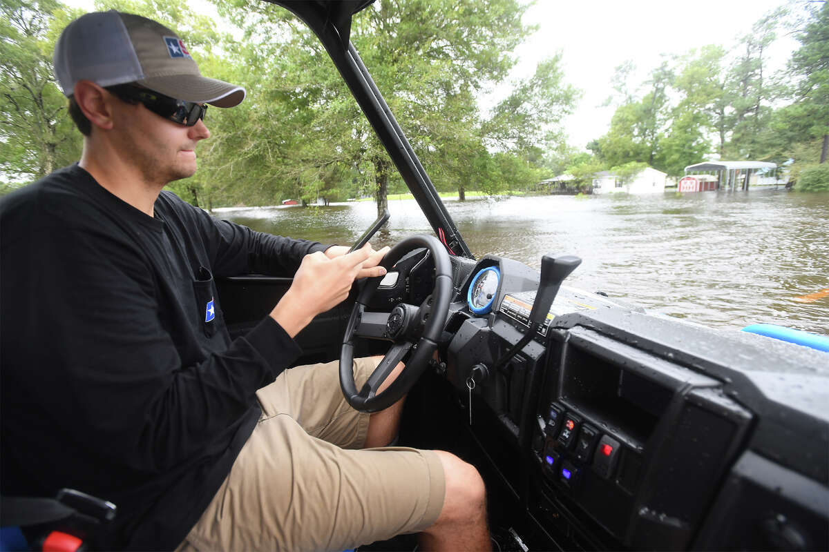 Matt Spence looks on his phone while driving through water on FM 365 near Interstate 10 on Tuesday. The mass of accurate and inaccurate information on social media has helped and hindered emergency response to Hurricane Harvey. Photo taken August 28, 2017 Guiseppe Barranco/The Enterprise