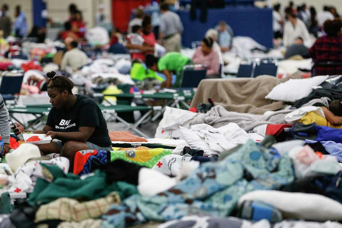 Markia Evans sits on a cot at the George R. Brown Convention Center where nearly 10,000 people are taking shelter after Tropical Storm Harvey Wednesday, Aug. 30, 2017 in Houston. ( Michael Ciaglo / Houston Chronicle)