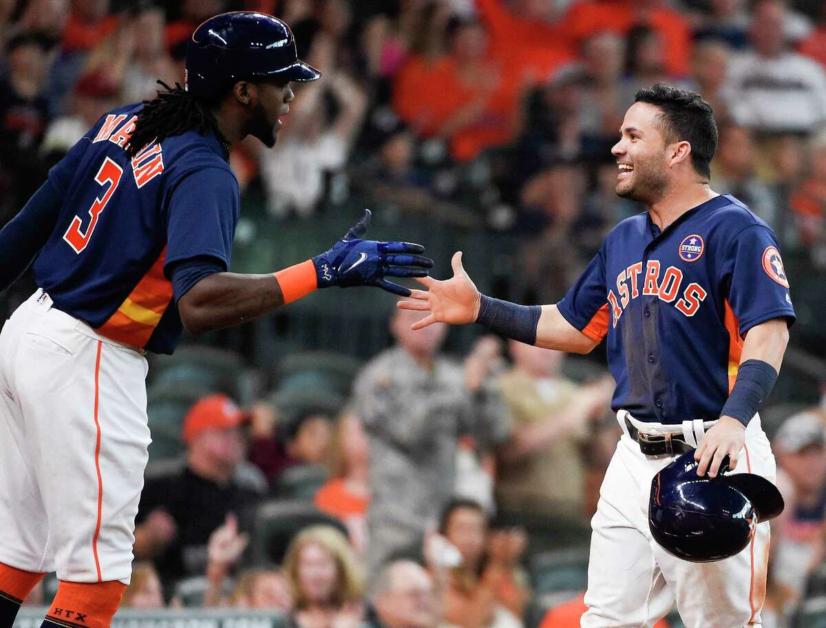 Houston Astros' Jose Altuve, right, celebrates scoring a run on Josh Reddick's sacrifice with Cameron Maybin during the seventh inning of a baseball game against the New York Mets, Sunday, Sept. 3, 2017, in Houston. (AP Photo/Eric Christian Smith)