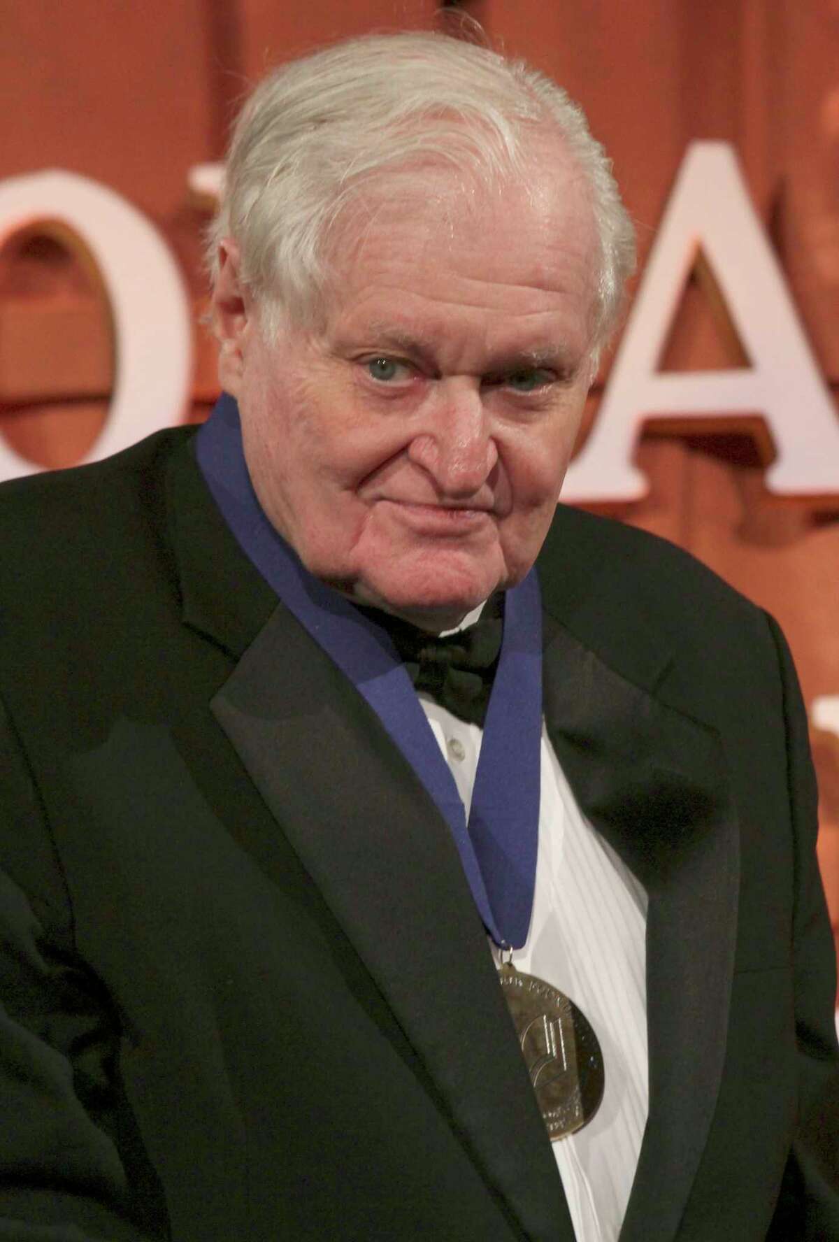 FILE - In this Wednesday Nov. 16, 2011, file photo,John Ashbery poses for photographs after being presented with the 2011 Medal for Distinguished Contribution to American Letters at the National Book Awards in New York. Ashbery, widely regarded as one of the world's greatest poets, died Sunday, Sept. 3, 2017, at home in Hudson, New York, of natural causes, according to husband, David Kermani. He was 90. (AP Photo/Tina Fineberg, File)