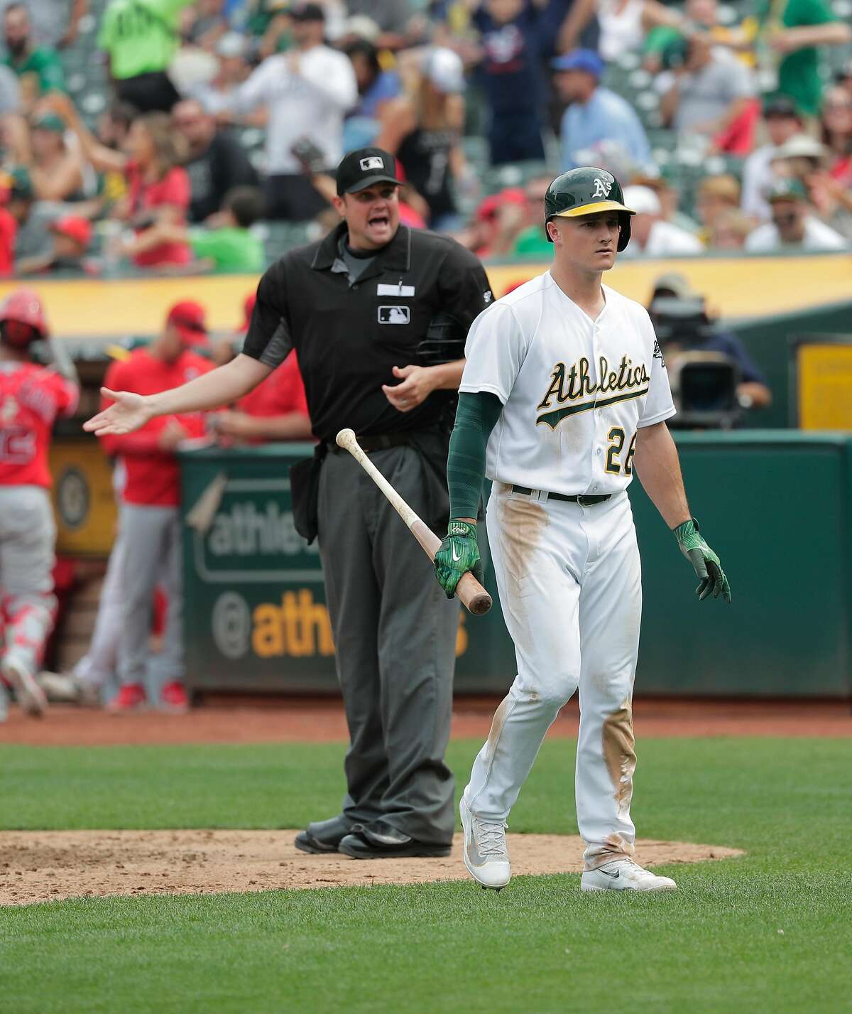 A's Matt Chapman, 26 walks back to the dugout after being called out looking to end the sixth inning as home plate umpire Jordan Baker barks back at Chapman, as the Oakland Athletics take on the Los Angeles Angels at the Oakland Coliseum in Oakland, Ca. on Mon. September 4, 2017.