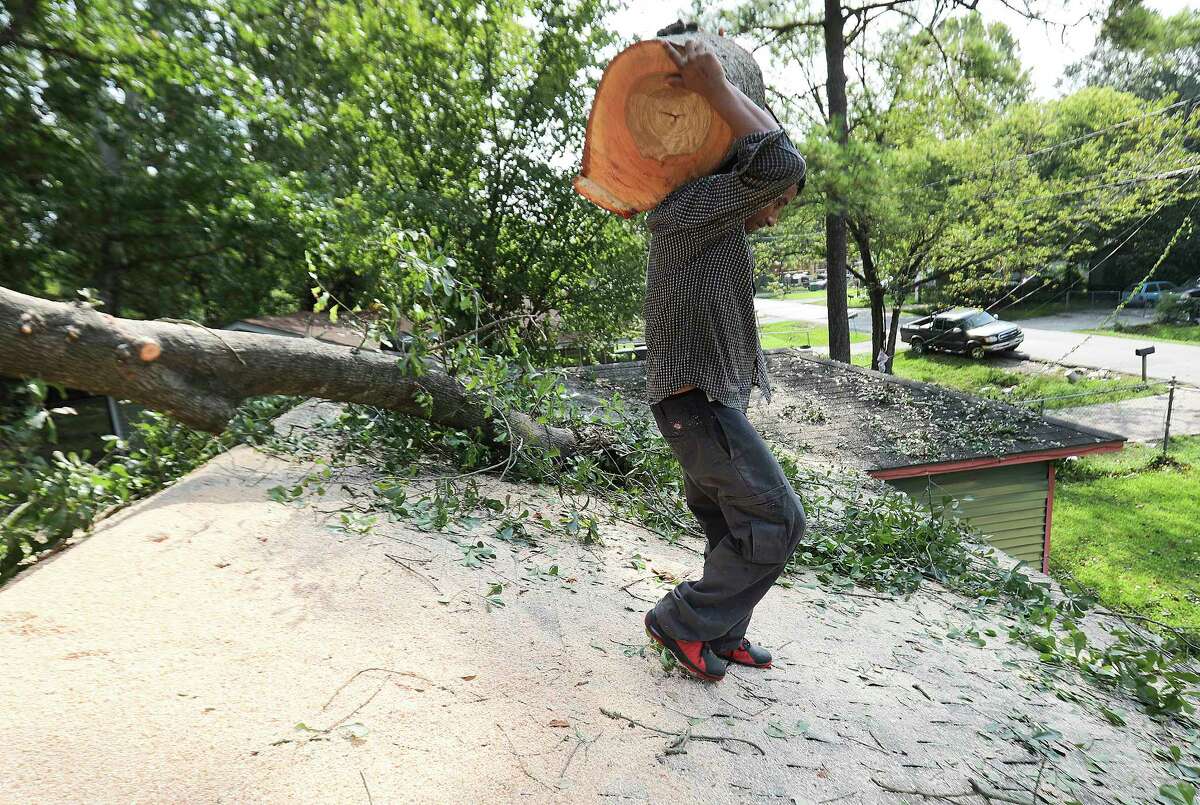 Arbor King Tree Service employee Jobany Berrios removes a tree stump from a roof of a home on Monday, Sept. 4, 2017, in Houston in the aftermath of Tropical Storm Harvey.