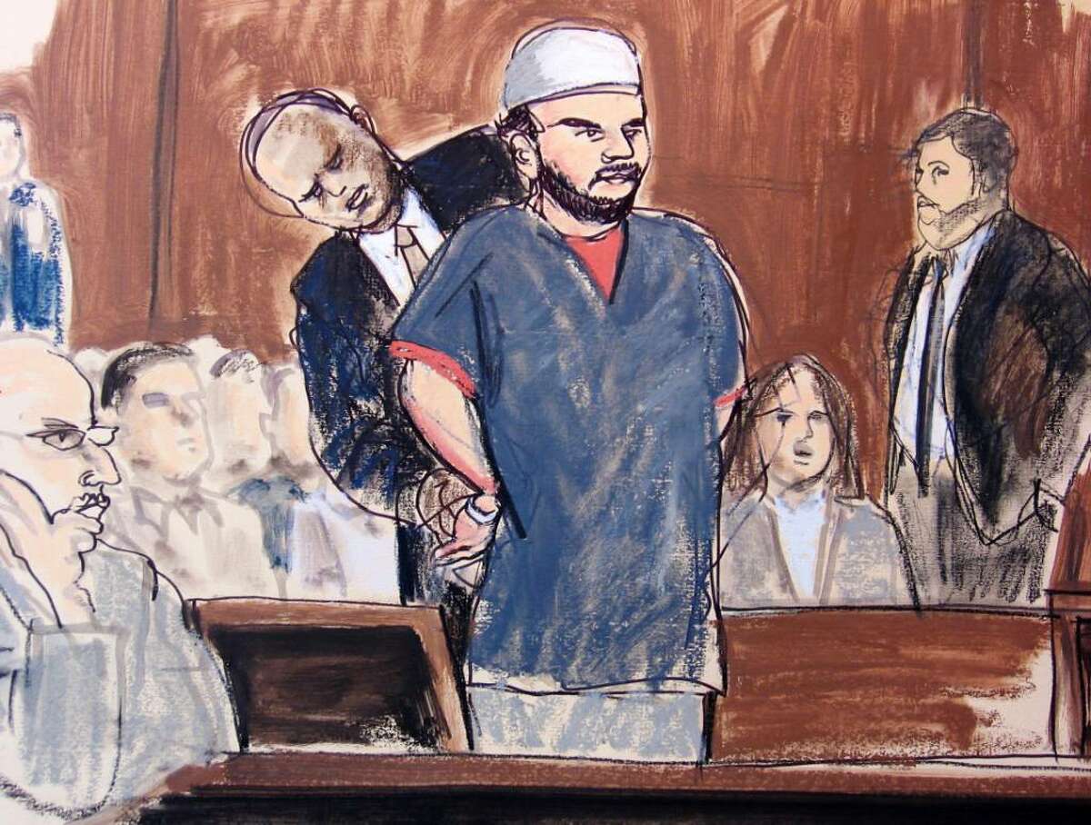 ** CORRECTS TO SAY U.S. MARSHALL REMOVES HANDCUFFS ** In this courtroom sketch, a U.S. Marshall removes Faisal Shahzad's handcuffs in the courtroom Monday, June 21, 2010, in New York. Shahzad, who appeared in federal court on an indictment accusing him of plotting a failed Times Square car bombing, was told by a judge that his hearing is being postponed until later Monday afternoon. He's accused in a plot that fizzled when a gasoline-and-propane bomb failed to ignite in a sport utility vehicle parked near a Broadway theater May 1. (AP Photo/Elizabeth Williams)