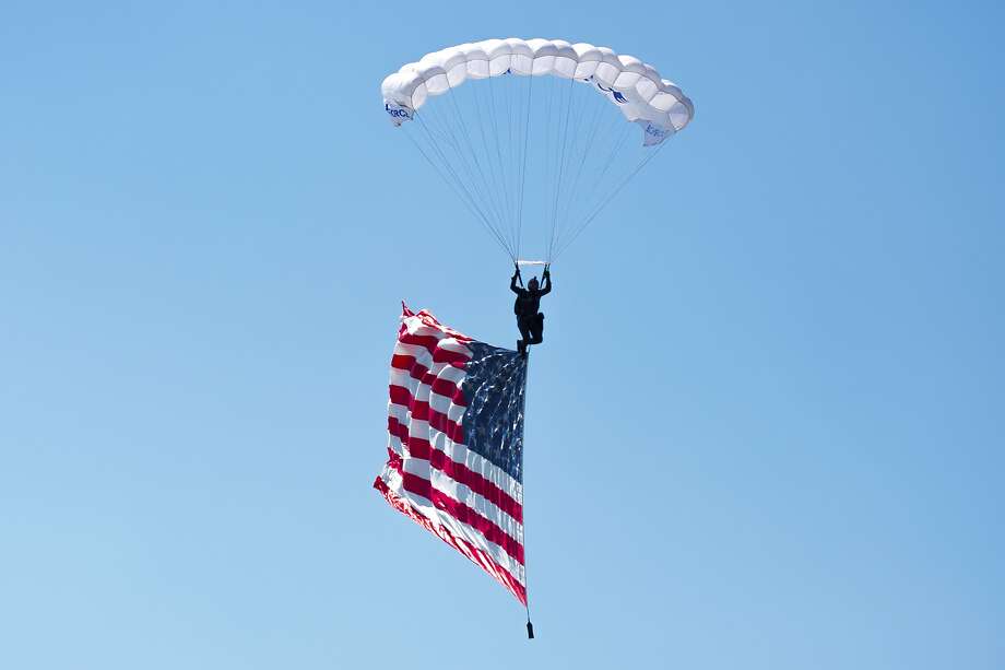 a parachutist carrying the american flag makes his way into