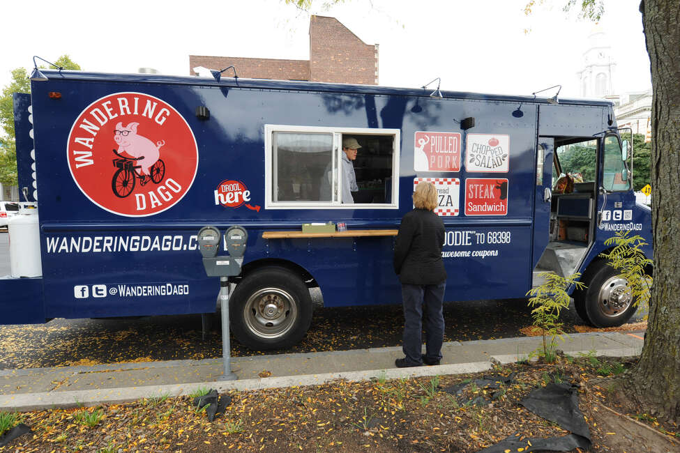 Andrea Loguidice talks to a customer as her boyfriend Brandon Snooks cooks the order on the Wandering Dago food truck outside Schenectady County Public Library Tuesday, Oct. 9, 2012 in Schenectady, N.Y. (Lori Van Buren / Times Union) ORG XMIT: MER2013082719341471