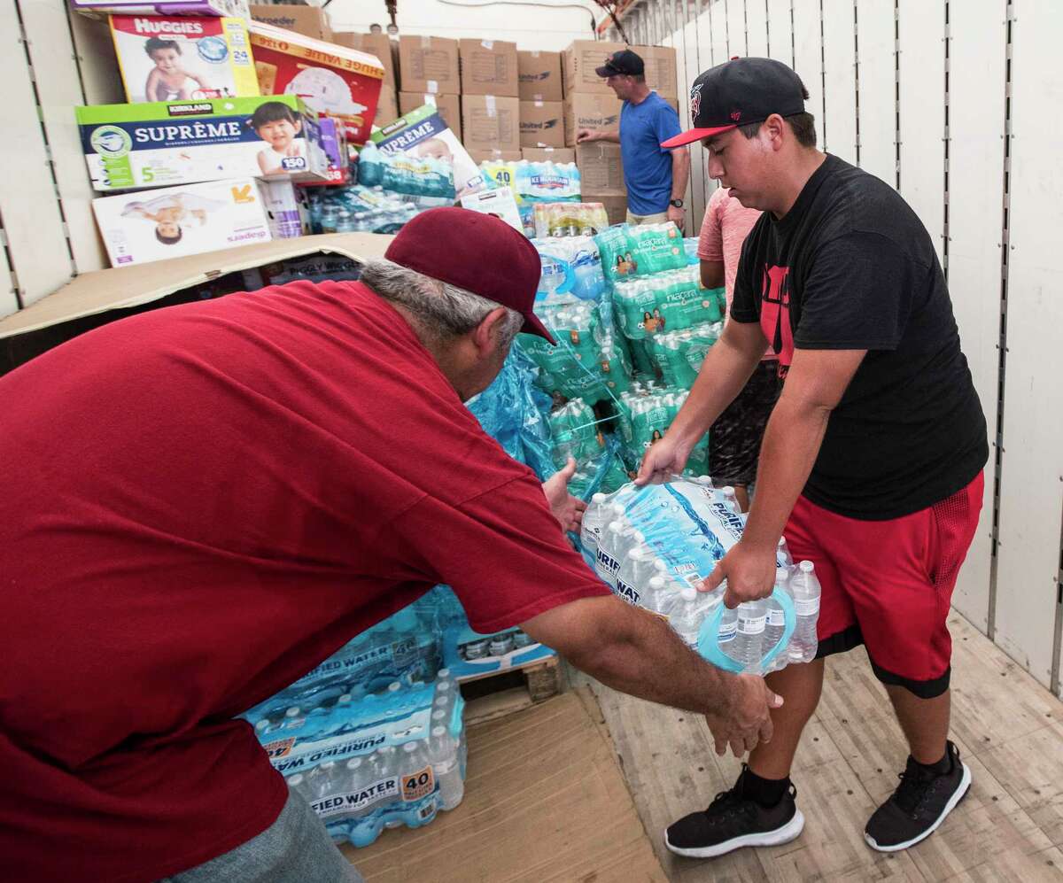 Volunteers unload a truck of relief supplies for people impacted by Hurricane Harvey on Sunday in Houston. ( Brett Coomer / Houston Chronicle, POOL )