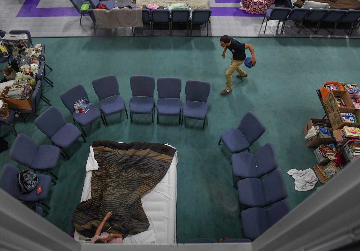 Harvey evacuee Jordan Vital, 26, and his girlfriend, Andrea Aragon, 20, pass the time around their living area Tuesday at Calvary Community Church in Houston. Must credit: Washington Post photo by Ricky Carioti