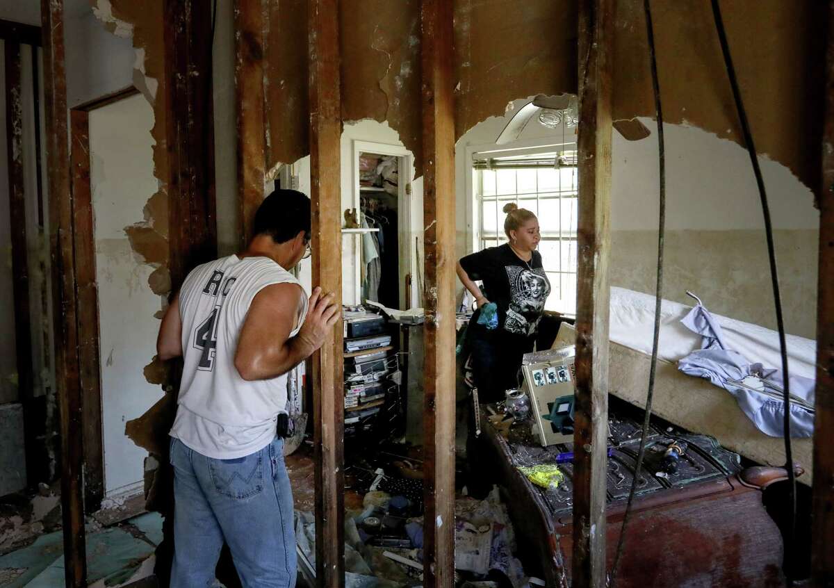 Rikki Saldivar, right, and her dad, Ric Saldivar, look at the damaged remains of a house that belonged to Ric Saldivar's parents, Sept. 5, 2017, in Houston. His parents and four young relatives drowned in a van in Greens Bayou during Tropical Storm Harvey. ( Jon Shapley / Houston Chronicle )