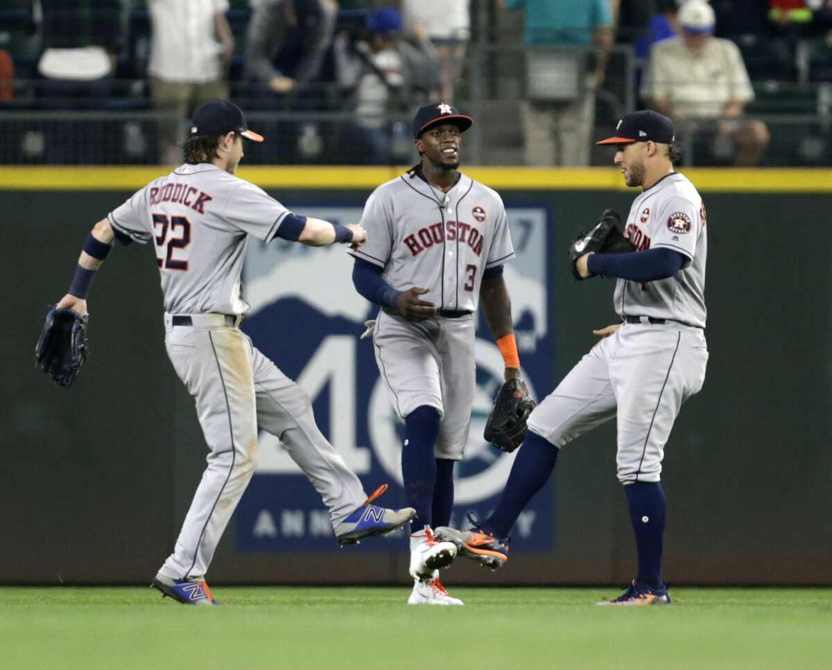 Houston Astros Josh Reddick, left, Cameron Maybin, center, and George Springer, right, celebrate a 5-3 win over the Seattle Mariners of a baseball game Wednesday, Sept. 6, 2017, in Seattle. (AP Photo/John Froschauer)